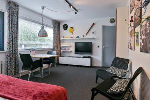 a room with a bed and a table and a television at BEDbijPET in Emmen
