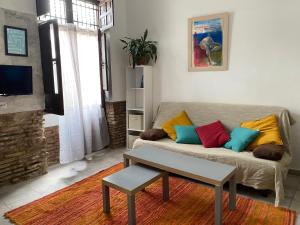 sala de estar con sofá y almohadas coloridas en Tranquilo Apartamento en el corazón del Albaicín, en Granada