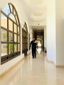a man walking down a hallway in a building at Jabal Akhdhar Hotel in Al ‘Aqar