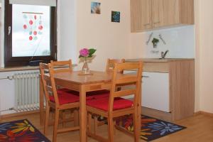 a kitchen with a wooden table and chairs with a vase at Ferienwohnung "Völkl" in Tännesberg