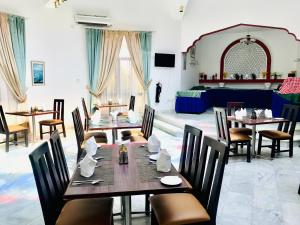 una sala da pranzo con tavoli, sedie e un letto di Jabal Akhdhar Hotel ad Al ‘Aqar