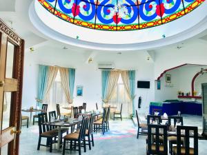 une salle à manger avec des tables et des chaises et un plafond dans l'établissement Jabal Akhdhar Hotel, à Al ‘Aqar