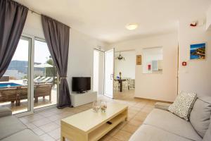 a living room with a couch and a tv at Aethrion Villa Lindos in Líndos