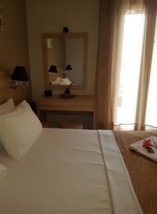 een slaapkamer met een bed, een bureau en een spiegel bij Studio Manousos in Plakias