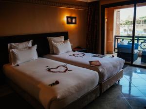 a hotel room with two beds with roses on them at Club Paradisio in Marrakesh