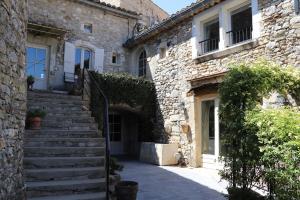 a stone building with stairs and a stair case at Clarberg - B&B in Saint-André-de-Roquepertuis