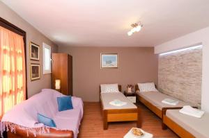 - un salon avec un canapé, un lit et une chaise dans l'établissement Guest House Ćuk, à Dubrovnik