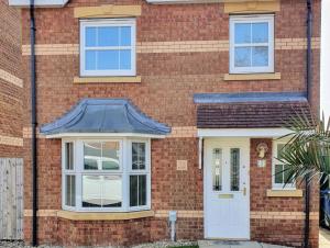 Beverley Central Townhouse Free Parking Sleeps 8 في بيفرلي: منزل من الطوب الأحمر مع باب أبيض