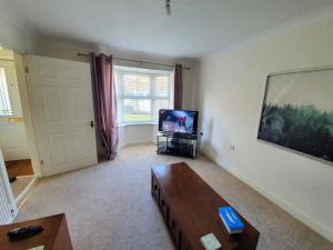 uma sala de estar com um sofá e uma televisão em Beverley Central Townhouse Free Parking Sleeps 8 em Beverley