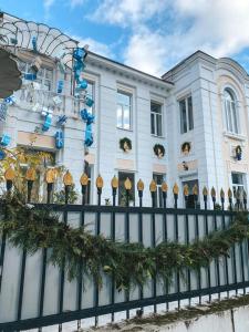 Un edificio con una valla con árboles de Navidad. en Бутик-отель Белый Дом Балерины, en Sukhum