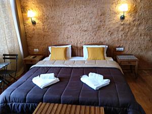 a bedroom with a large bed with two towels on it at Santrivani Rooms in Chania Town