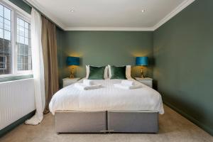 een slaapkamer met een groot bed met groene muren bij Stylish Upper Gardner Street - With Free Parking in Brighton & Hove