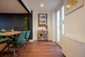 a dining room with a table and green chairs at Stylish Upper Gardner Street - With Free Parking in Brighton & Hove