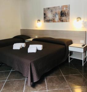 una camera d'albergo con due letti con asciugamani sopra di Hotel Nazionale a Firenze Altre 18 foto