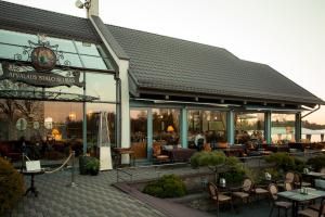 a restaurant with tables and chairs in front of it at Apvalaus Stalo Klubas Gastro & SPA Hotel in Trakai