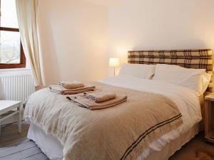 1 dormitorio con 1 cama con toallas en Small Brook Cottage, en Hay-on-Wye
