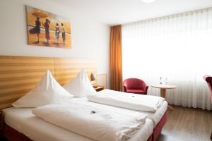 Postel nebo postele na pokoji v ubytování ates Hotel Kehl