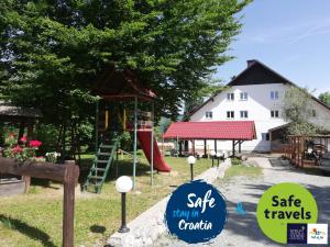 einen Spielplatz mit Rutsche und Spielstruktur in der Unterkunft Guesthouse Arnika in Fužine