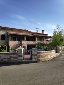 a brick house with a garage and a driveway at Apartmani Memić 100 m do plaže, APARTMENTS MEMIĆ ONLY 100M FROM BEACH in Poreč