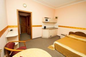 sypialnia z łóżkiem i stołem oraz kuchnia w obiekcie Viva Hotel w mieście Mikołajów