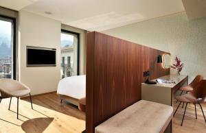 a hotel room with a bed and a desk and chairs at Grand Hotel Victoria concept & spa, by R Collection Hotels in Menaggio