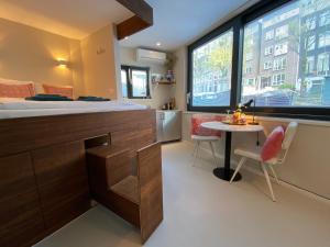 a bedroom with a bed and a table and a window at Houseboat Sophia in Amsterdam