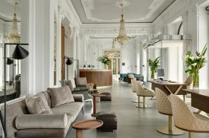 a living room with a couch and tables and chairs at Grand Hotel Victoria concept & spa, by R Collection Hotels in Menaggio