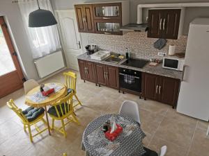 a kitchen with a table and chairs and a kitchen with a refrigerator at Edith's House in Turda