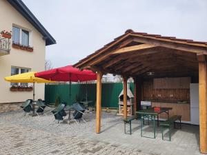 un patio avec des tables, des chaises et des parasols dans l'établissement Edith's House, à Turda