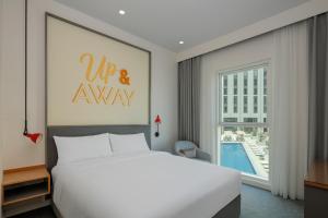 a bedroom with a large bed and a large window at Rove At The Park in Dubai