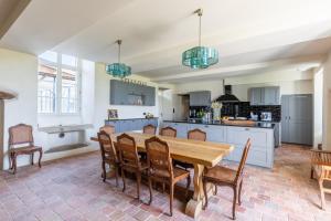 a kitchen and dining room with a wooden table and chairs at Manoir du Guern in Pluvigner
