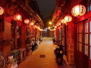 una calle estrecha por la noche con luces chinas en 媽宮古街10號 en Magong