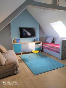 a attic room with a bed and a tv at La Nacelle, classée 3 étoiles, vue dégagée port et mer in Le Tréport