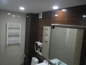 a bathroom with a mirror and a sink at Two Lions Hotel in Tbilisi City