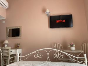 a bedroom with a bed and a tv on the wall at La Soffitta di EmmaSofia in San Vito