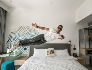 a man jumping in the air on a bed at Rove La Mer Beach, Jumeirah in Dubai