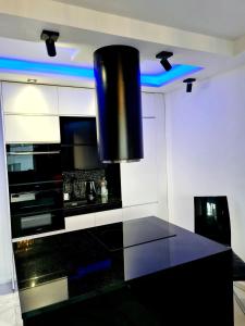 uma cozinha com um balcão preto e luzes azuis em Apartament Przy Starym Mieście em Szczecin