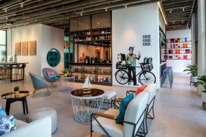 a restaurant with chairs tables and a bike on the wall at Rove La Mer Beach, Jumeirah in Dubai