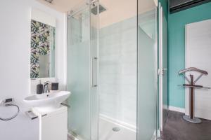 W łazience znajduje się szklana kabina prysznicowa i umywalka. w obiekcie Nador Boutique- Best Location, By BQA w Budapeszcie