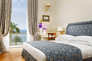 a bedroom with a bed and a view of the ocean at Royal Hotel Sanremo in Sanremo