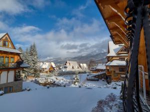 eine Stadt voller Schnee mit Bergen im Hintergrund in der Unterkunft Apartament Śnieżny Deluxe Odkryj Zakopane in Kościelisko