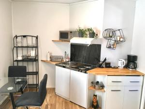 a kitchen with white cabinets and a stove top oven at Apartment with garden and teracce- Free parking in Oulu
