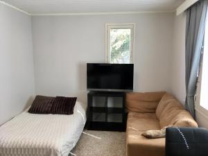 a living room with a couch and a flat screen tv at Apartment with garden and teracce- Free parking in Oulu