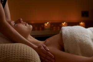 Una donna sdraiata su un divano con un asciugamano di The Vineyard Hotel & Spa a Newbury