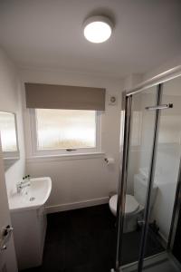 uma casa de banho com um lavatório, um WC e uma janela. em Burnbank Lodges em Spean Bridge
