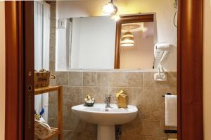 ein Bad mit einem Waschbecken und einem Spiegel in der Unterkunft B&B La Corte San Francesco in Bari
