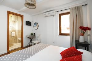 a bedroom with a bed with red pillows and a bathroom at B&B La Corte San Francesco in Bari