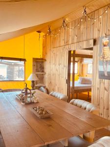 a dining room with a wooden table and a bed at Casa Chiquito in Savaneta