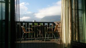 a balcony with two chairs and a table with a view at Jimei Homestay in Ji'an