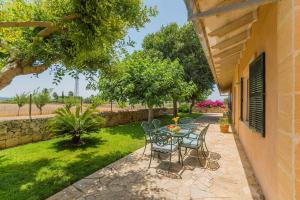 a patio with a table and chairs in a yard at Finca Amer in Sa Pobla